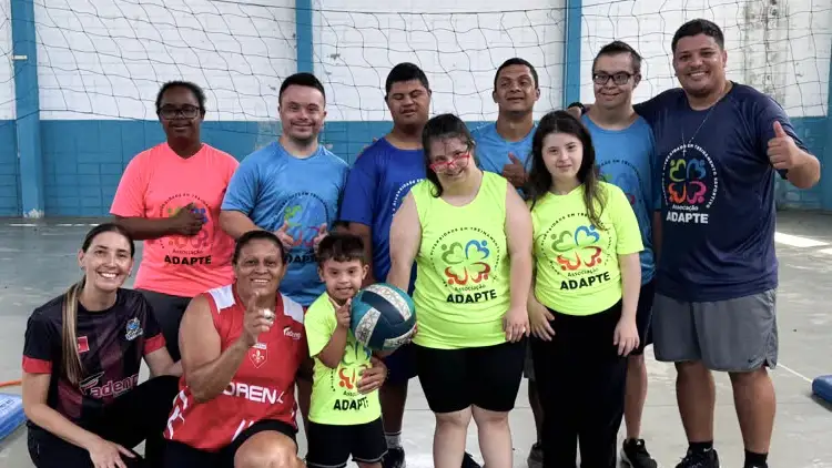 Grupo da ADAPTE em quadra com uma bola de vôlei